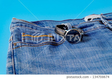 Black watch in blue jeans pocket.Fashion concept. Black watch in blue jeans pocket.Fashion concept. 134708674