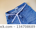 Blue jeans with measuring tape on color background. 134708689