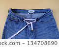 Blue jeans with measuring tape on color background. 134708690