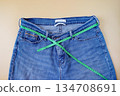 Blue jeans with measuring tape on color background. 134708691