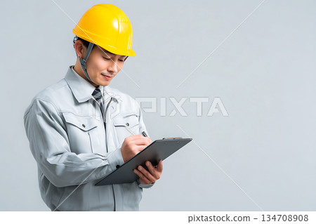 一名戴著安全帽的現場工作人員正在用平板電腦查看工作狀況。 134708908