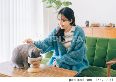 女子照顧正在吃東西的貓 134709051