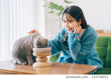 女子照顧正在吃東西的貓 134709052