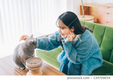 女子照顧正在吃東西的貓 134709054