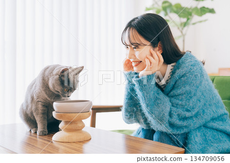 女子照顧正在吃東西的貓 134709056