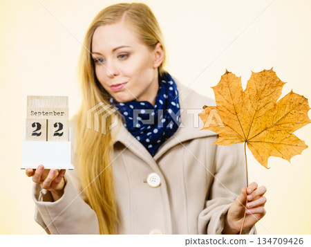 Woman holding calendar with first autumn day 134709426