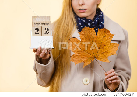 Woman holding calendar with first autumn day 134709427