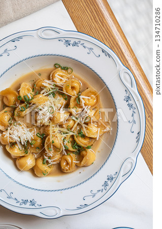 Pelmeni dumplings with creamy sauce and cheese 134710286