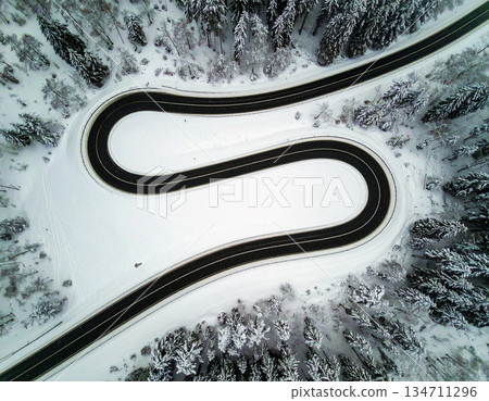 a winding road in a snowy landscape 134711296