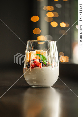 Creamy dessert in glass with berries and mint Creamy dessert in glass with berries and mint 134711331