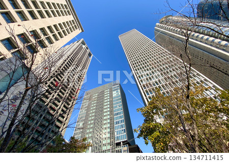 城市景觀,仰望摩天大樓在藍天下巍峨聳立。 城市景觀,仰望摩天大樓在藍天下巍峨聳立。 134711415