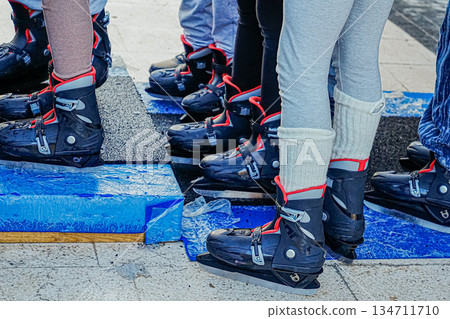 Close Up of Multiple Legs in Ice Skates Standing in Line Close Up of Multiple Legs in Ice Skates Standing in Line 134711710