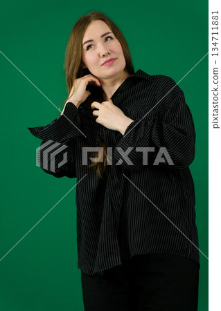 Confident young businesswoman adjusting her hair, exuding professionalism and style in a blue suit against a white background Confident young businesswoman adjusting her hair, exuding professionalism and style in a blue suit against a white background 134711881