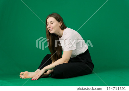 Woman thinking sitting on a couch at home looking away through a window 134711891