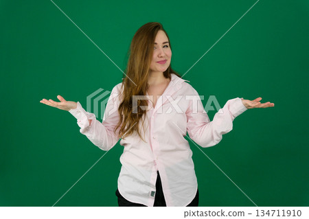 Careless attractive Beautiful pregnant woman wearing green T-shirt standing over white studio background shrugging shoulders, oops. 134711910
