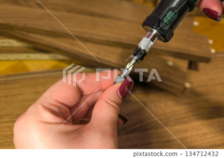 Small parts for furniture assembly against a background of wooden panels. Assembling furniture at home and doing home repairs yourself. High quality photo Small parts for furniture assembly against a background of wooden panels. Assembling furniture at home and doing home repairs yourself. High quality photo 134712432