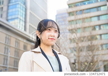 一位二十多歲、面容姣好的年輕女商人,身著職業套裝,在建築工地上面帶微笑。 一位二十多歲、面容姣好的年輕女商人,身著職業套裝,在建築工地上面帶微笑。 134712471