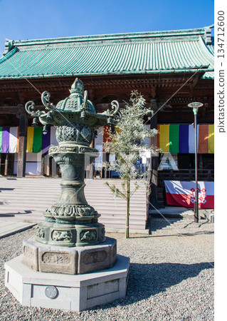 Stone lanterns with historical decorations under bright sunlight and clear blue skies at Gokokuji Temple in Tokyo Stone lanterns with historical decorations under bright sunlight and clear blue skies at Gokokuji Temple in Tokyo 134712600