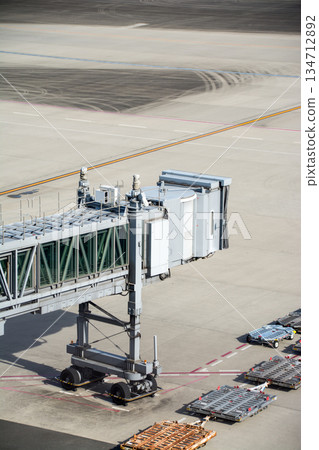 在東京羽田機場，乘客們在登機橋上沐浴著明媚的陽光，等待著航班的到來。 134712892