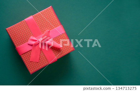 Christmas background with copy space over green desk. Card with red gift for your design 134713275