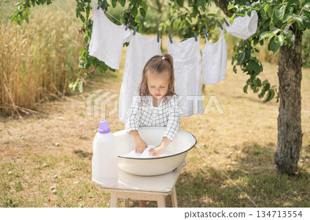 Hand washing of white linen and clothes. Bleaching and preserving whiteness with detergent and liquid detergents 134713554