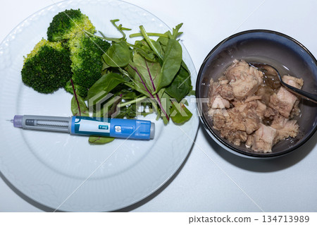 Healthy salad with tuna and Ozempic pen for diet concept Healthy salad with tuna and Ozempic pen for diet concept 134713989