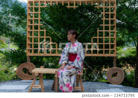 宇賀部神社:一位身穿浴衣的女子正坐著。 宇賀部神社:一位身穿浴衣的女子正坐著。 134715795