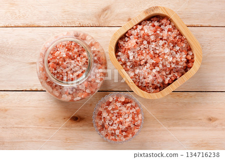 Himalayan salt crystals in wooden and glass containers on a light wood table Himalayan salt crystals in wooden and glass containers on a light wood table 134716238