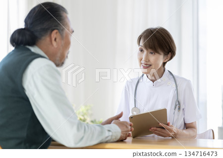 女醫生和醫護人員正在聽一位資深男士講話 134716473
