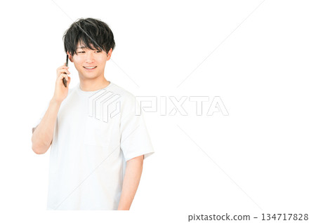 一位年輕的亞裔男子正在用他的智慧型手機打電話 134717828