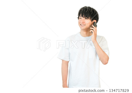 一位年輕的亞裔男子正在用他的智慧型手機打電話 134717829