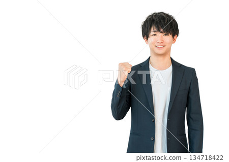 一位身穿夾克的年輕商人揮舞著拳頭(積極、期待、快樂、成功、精力充沛、高興、喜悅) 一位身穿夾克的年輕商人揮舞著拳頭(積極、期待、快樂、成功、精力充沛、高興、喜悅) 134718422