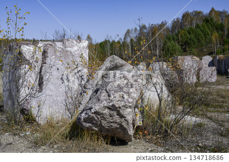 Huge cubic and geometric stone shapes in an abandoned marble quarry in autumn forest in Siberia 134718686