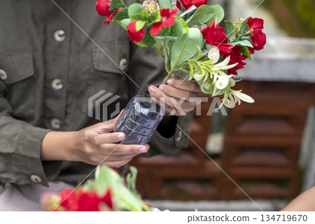 People gathered outdoors, actively participating in a recycling initiative. Decorating with plastic bottles promotes environmental sustainability. Spirit of eco-consciousness People gathered outdoors, actively participating in a recycling initiative. Decorating with plastic bottles promotes environmental sustainability. Spirit of eco-consciousness 134719670