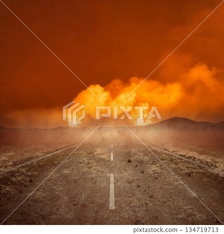 Desolate road stretches towards an apocalyptic scene featuring a massive cloudscape of explosive flames. The landscape is dry and barren. Extreme weather background Desolate road stretches towards an apocalyptic scene featuring a massive cloudscape of explosive flames. The landscape is dry and barren. Extreme weather background 134719713