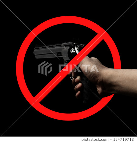 Human hand holding a revolver handgun with a red circle and diagonal line across it. Symbolize the prohibition of gun violence. Concept of gun violence 134719718
