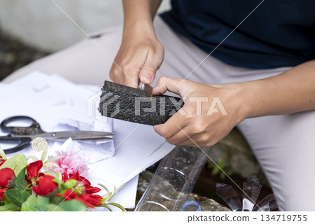 People gathered outdoors, actively participating in a recycling initiative. Decorating with plastic bottles promotes environmental sustainability. Spirit of eco-consciousness 134719755