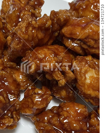Crispy Korean fried chicken, perfectly glazed with a sweet and spicy sauce. Ideal for food photography and menus, showcasing the irresistible crunch and flavor of this beloved dish. 134721710