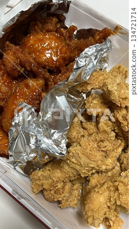 Crispy Korean fried chicken, perfectly glazed with a sweet and spicy sauce. Ideal for food photography and menus, showcasing the irresistible crunch and flavor of this beloved dish. 134721714