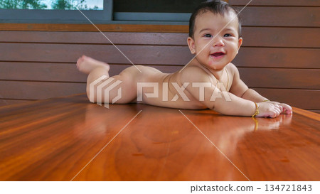 cute asian baby girl smiling while sitting on floor 134721843