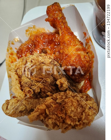 Crispy Korean fried chicken, perfectly glazed with a sweet and spicy sauce. Ideal for food photography and menus, showcasing the irresistible crunch and flavor of this beloved dish. 134722199