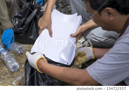 Indonesian southeast asian people wearing aprons and gloves in a cleanup activity. Holding trash bags filled with garbage. Protecting the environment by cleaning up litter Indonesian southeast asian people wearing aprons and gloves in a cleanup activity. Holding trash bags filled with garbage. Protecting the environment by cleaning up litter 134722557