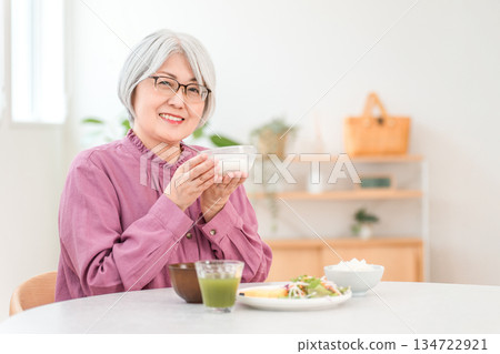A senior woman with gray hair who eats yogurt and dairy products for breakfast (bifidobacteria, lactic acid bacteria, dairy products, gut health). A senior woman with gray hair who eats yogurt and dairy products for breakfast (bifidobacteria, lactic acid bacteria, dairy products, gut health). 134722921
