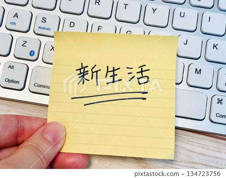一隻手拿著一張便條紙,上面寫著「新生活」 + 電腦 一隻手拿著一張便條紙,上面寫著「新生活」 + 電腦 134723756