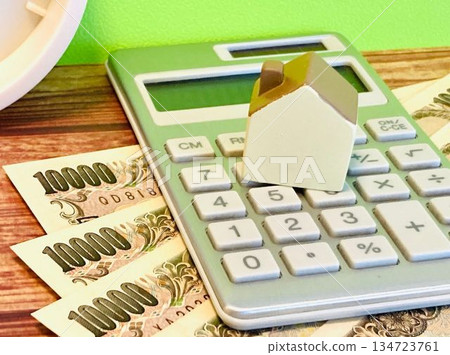 Money, a calculator and a model house 134723761