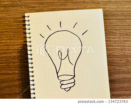 A notebook with a hand-drawn illustration of a light bulb 134723763