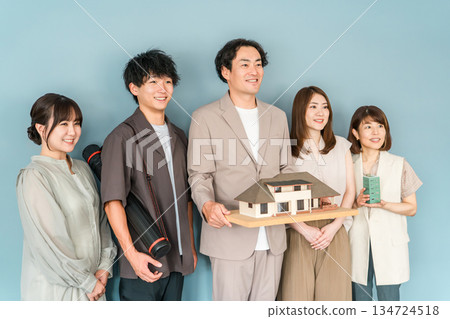 房屋製造商、設計辦公室或建築公司的男女員工拿著建築模型或房屋模型 134724518