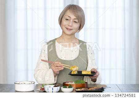 Senior woman making lunch in the kitchen Senior woman making lunch in the kitchen 134724581