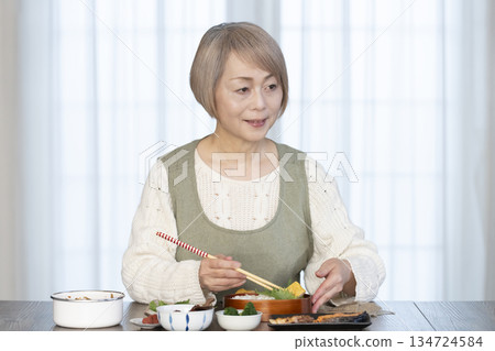 Senior woman making lunch in the kitchen Senior woman making lunch in the kitchen 134724584