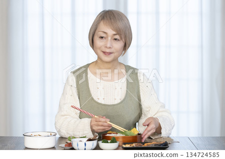 Senior woman making lunch in the kitchen Senior woman making lunch in the kitchen 134724585